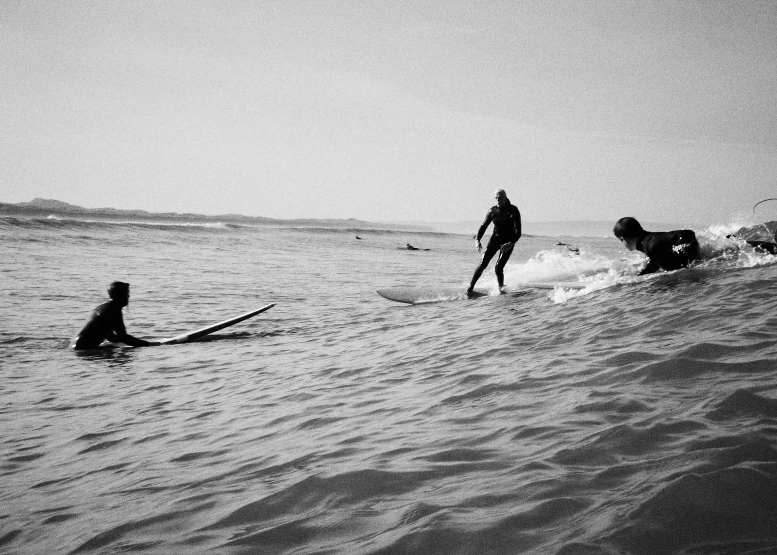 Surfers on a wave, black and white